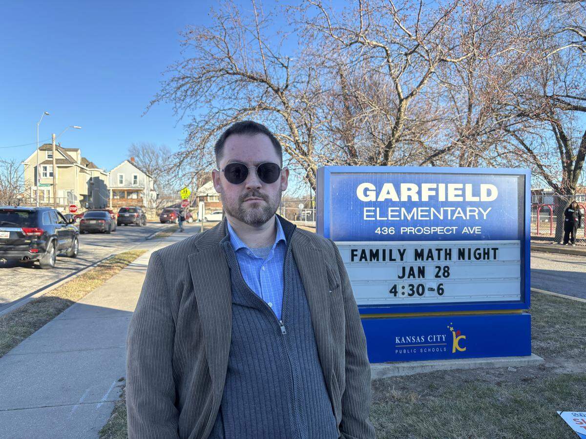Benjamin Roesler poses in front of the Garfield Elementary sign in Kansas City’s Pendleton Heights neighborhood. Roesler helped organized residents throughout the Northeast to keep watch during school pickup after ICE was spotted near the school Tuesday, Jan. 6.