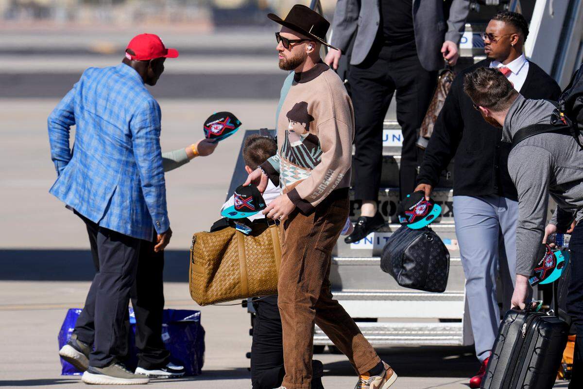 Kansas City Chiefs tight end Travis Kelce, center, and team arrive ahead of Super Bowl 57, Sunday, Feb. 5, 2023, in Phoenix. The Kansas City Chiefs will play the Philadelphia Eagles on Sunday.