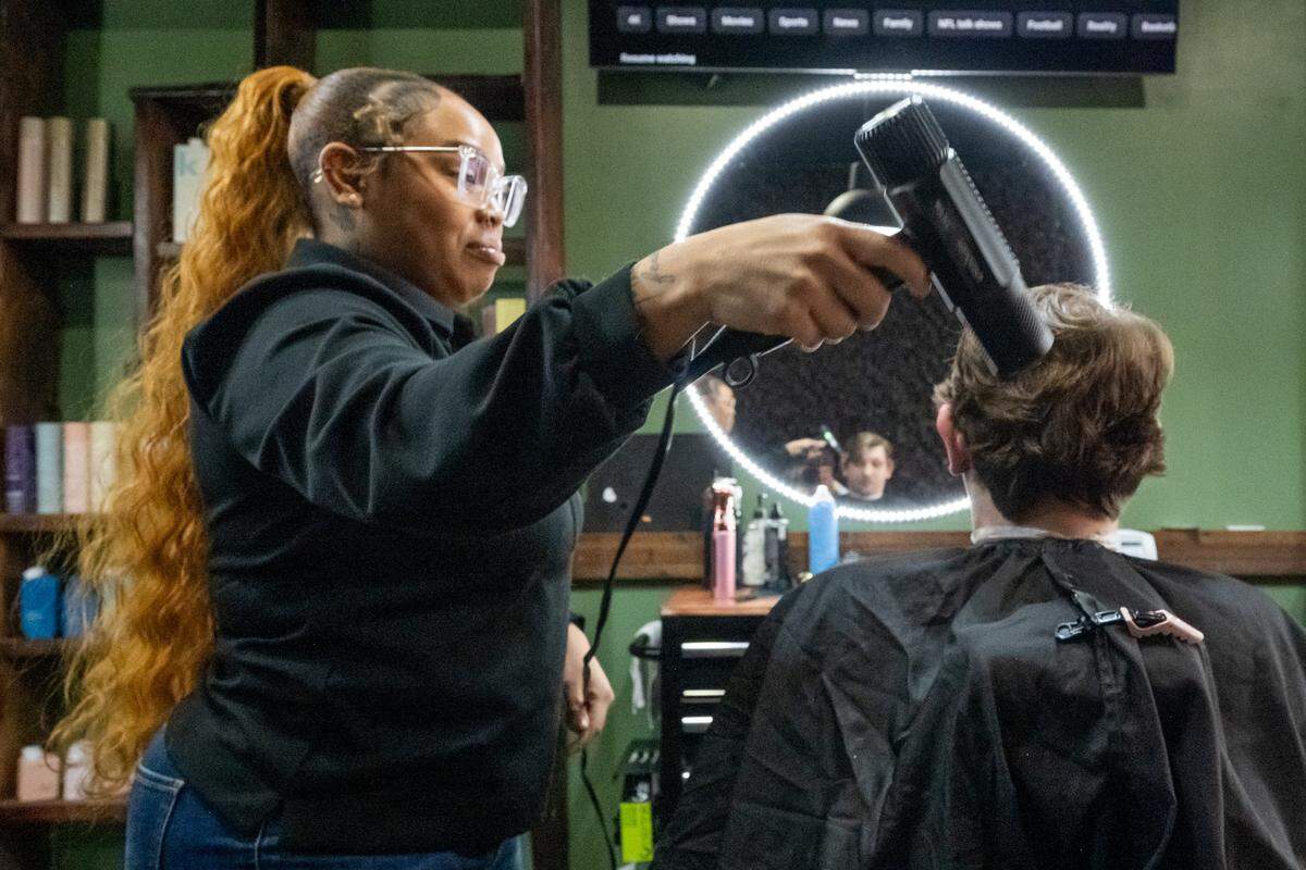 Tehya Smith blows cut hair off a client at Klassic Guy Barber Lounge on 9th, on Tuesday, February 3, 2026, in Kansas City.