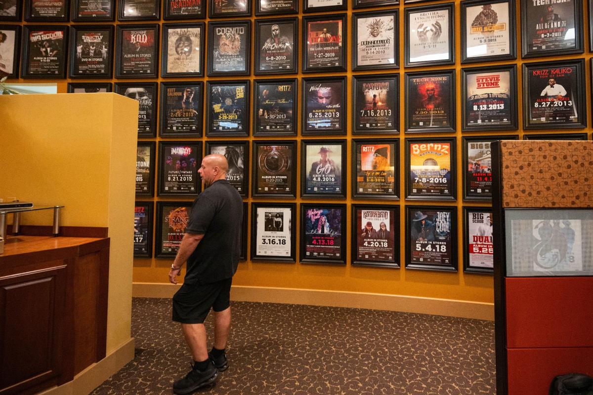 Strange Music President and CEO Travis O’Guin shows off his latest project, a floor to ceiling alphabetical wall design featuring posters from past and present recording artists signed to his Strange Music record label.