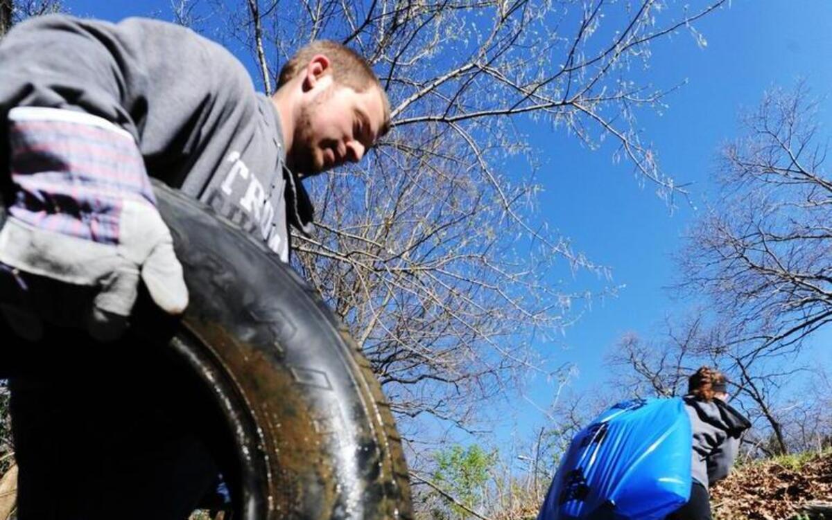In Swope Park, Justin Sextro of Kansas City followed his wife, Natalie Sextro, uphill Saturday as he hauled a wet tire from a small creek that feeds into the Blue River.