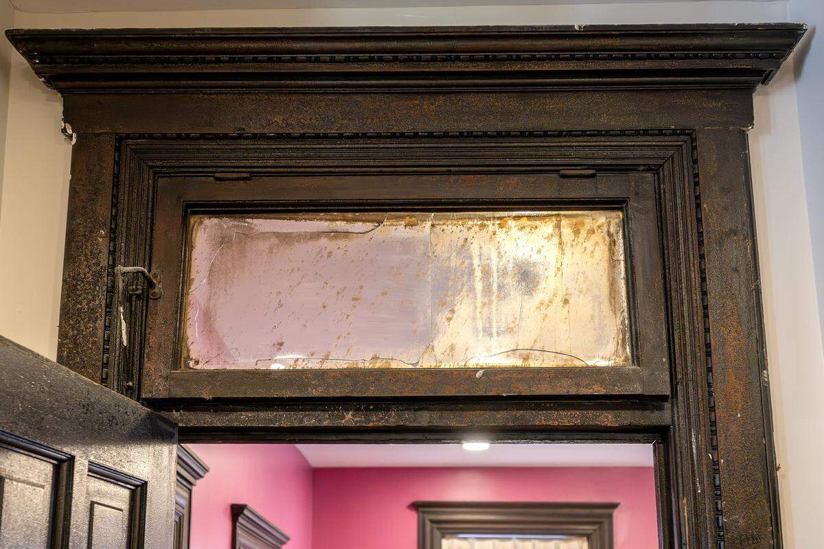 A doorway shows smoke and fire damage, including a cracked upper window, at the Bezanson family home on Wednesday, April 8, 2026, in Kansas City.