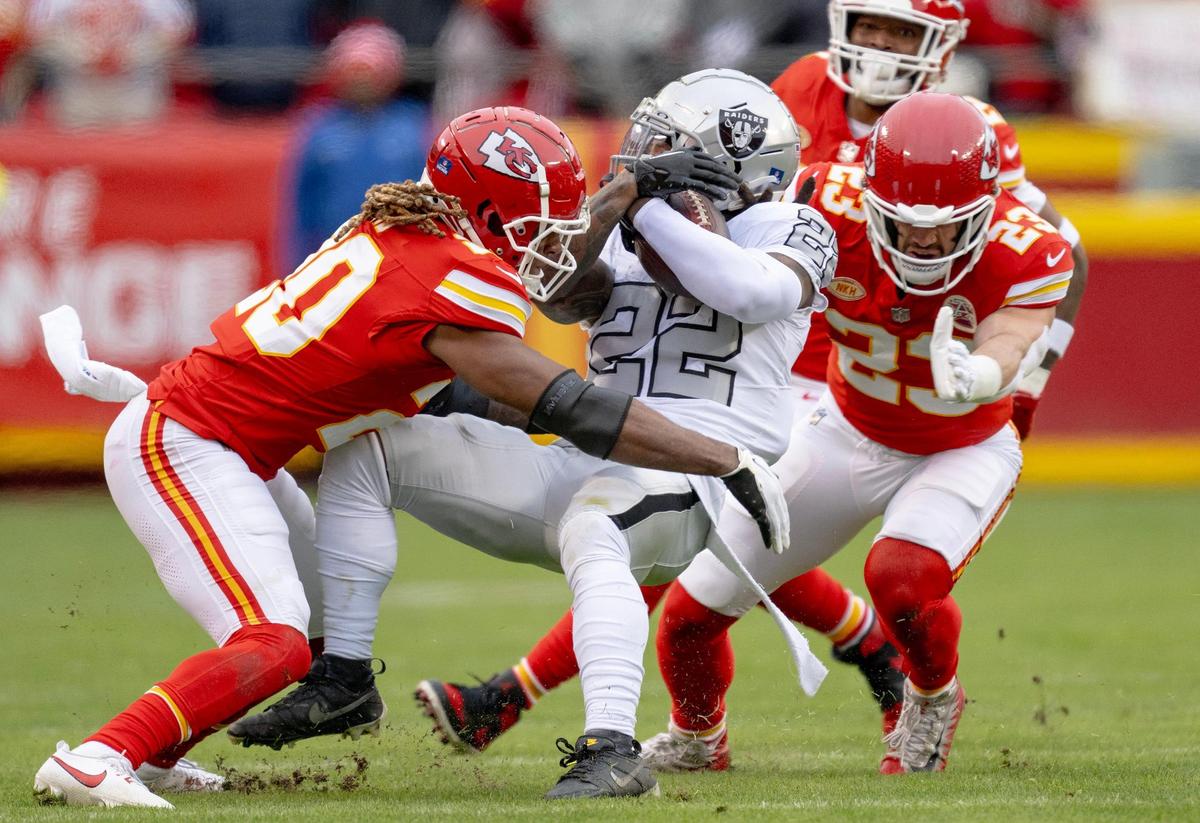 Kansas City Chiefs linebacker Drue Tranquill (23) and safety Justin Reid (20) tackle Las Vegas Raiders running back Ameer Abdullah (22) during an NFL football game on Monday, Dec. 25, 2023, at Arrowhead Stadium at GEHA Field in Kansas City.