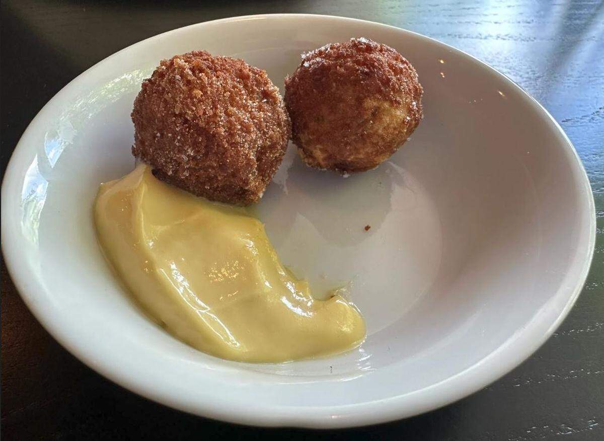 Bacaro Primo’s fried olives — green olives stuffed with a clove of roasted garlic, wrapped in spicy Italian sausage and deep fried.