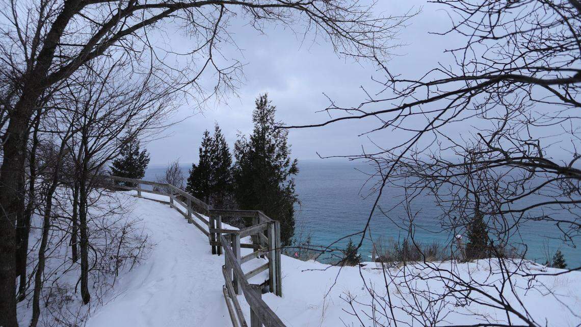 Firefighters rappelled down Empire Bluff Trail in Michigan to rescue two people who were trapped, officials say.
