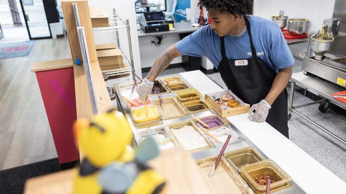 James Frazier, an employee at the Lee’s Summit Duck Donuts shop, prepares a box of donuts on Thursday, April 23.