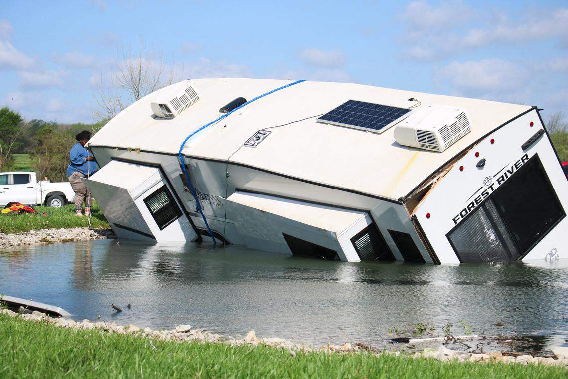 Tonja Gilbert, 53, looks at her RV as it sits in a pond at Shady Acres RV Park near Hillsdale, Kansas.