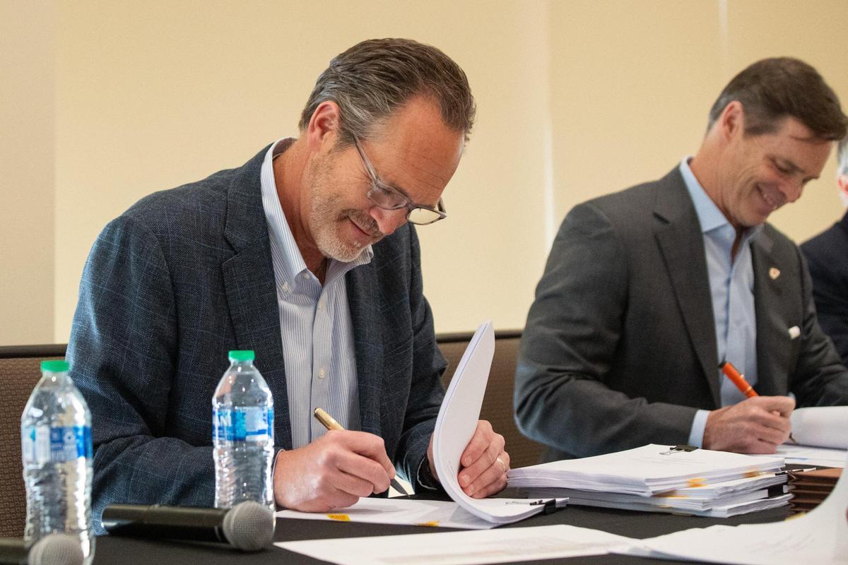 Kansas City Royals business operations president Brooks Sherman, left, and Kansas City Chiefs president Mark Donovan sign stadium lease agreements on Wednesday, March 27, 2024, at Arrowhead Stadium.