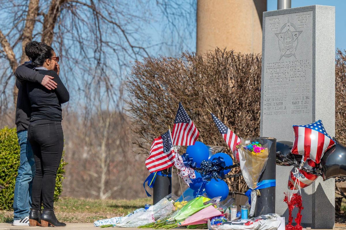 Visitors embrace each other after dropping off flowers Friday, March 1, 2024, at the Independence Police Department’s memorial for fallen officers to remember officer Cody Allen. Officer Allen along with Jackson County civil process server Drexel Mack were both killed when Mack attempted to serve an eviction notice.