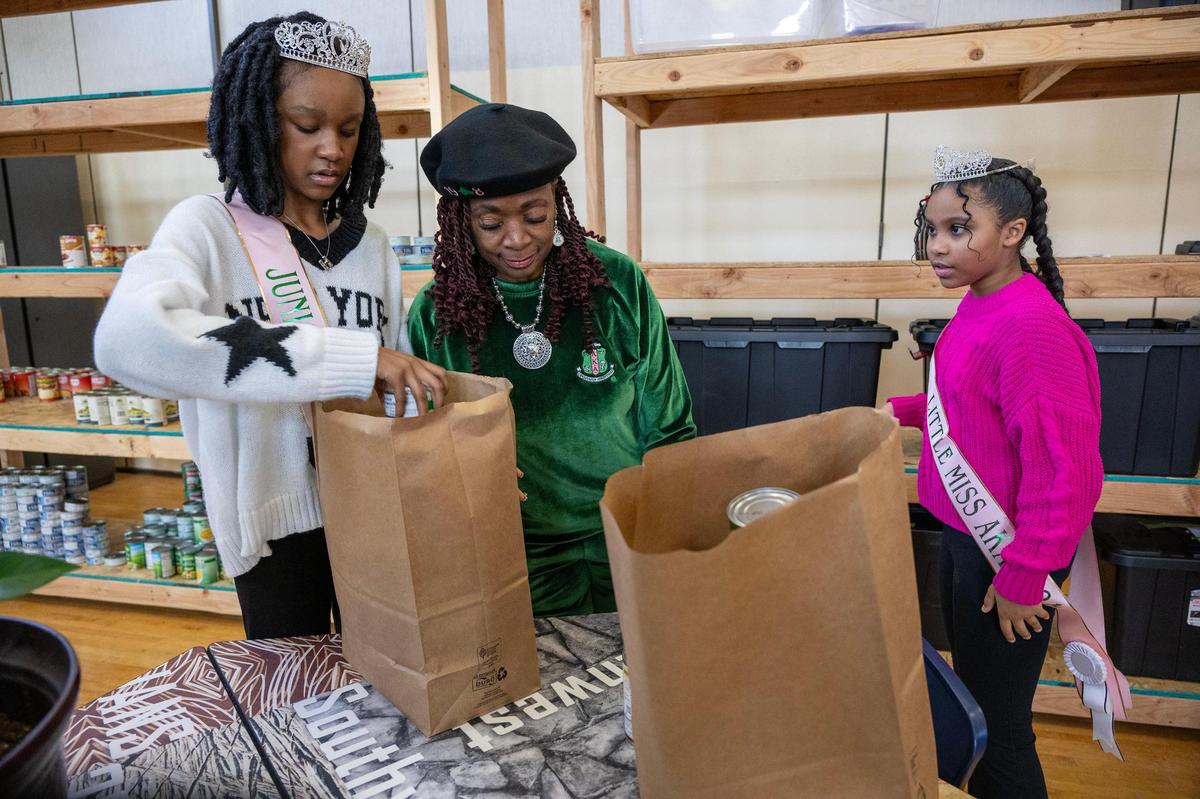Little Miss AKA Harleigh Reed, 12, of Raytown, from left, Josephine Patterson and Little Miss AKA Junior Lauryn Griffin, 9, of Raymore, packed bags of food during the during We Are ONE, Alpha Kappa Alpha Day of Service at Martin Luther King Jr. Elementary School on Monday, Jan. 20, 2025, in Kansas City.
