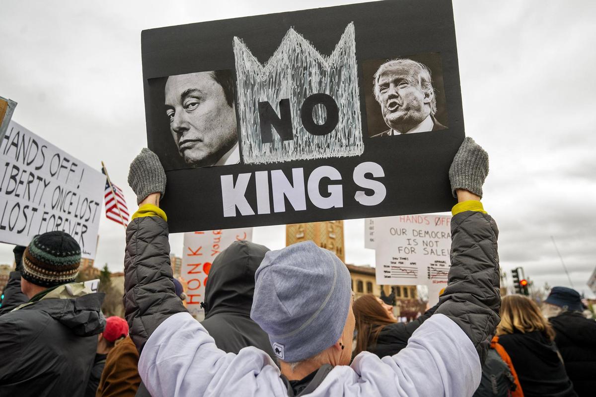 A protester held a sign reading “No Kings” during Hands Off! Kansas City Fights Back in response to some of the policies and actions of Elon Musk and Donald Trump.