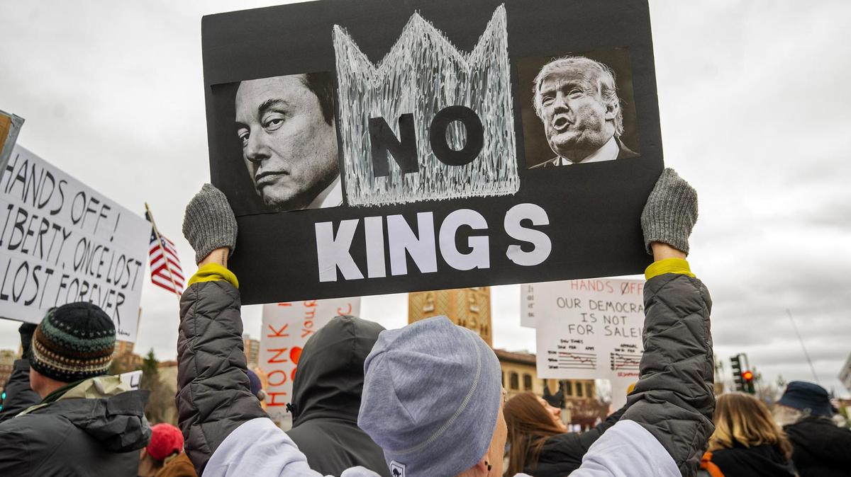 A protester held a sign reading ‘No Kings’, during a Hands Off! Kansas City Fights Back, a peaceful pro-democracy rally that takes aim at the Trump administration’s policies and Elon Musk’s involvement in it on Saturday, April 5, 2025, on the Country Club Plaza in Kansas City.