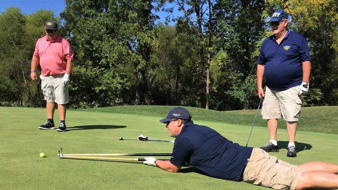 Paul Bridges lines his tee shot up with a pool cue. Bridges is a member of the Basehor VFW, one of the sponsors of the Combat Golf Tournament.