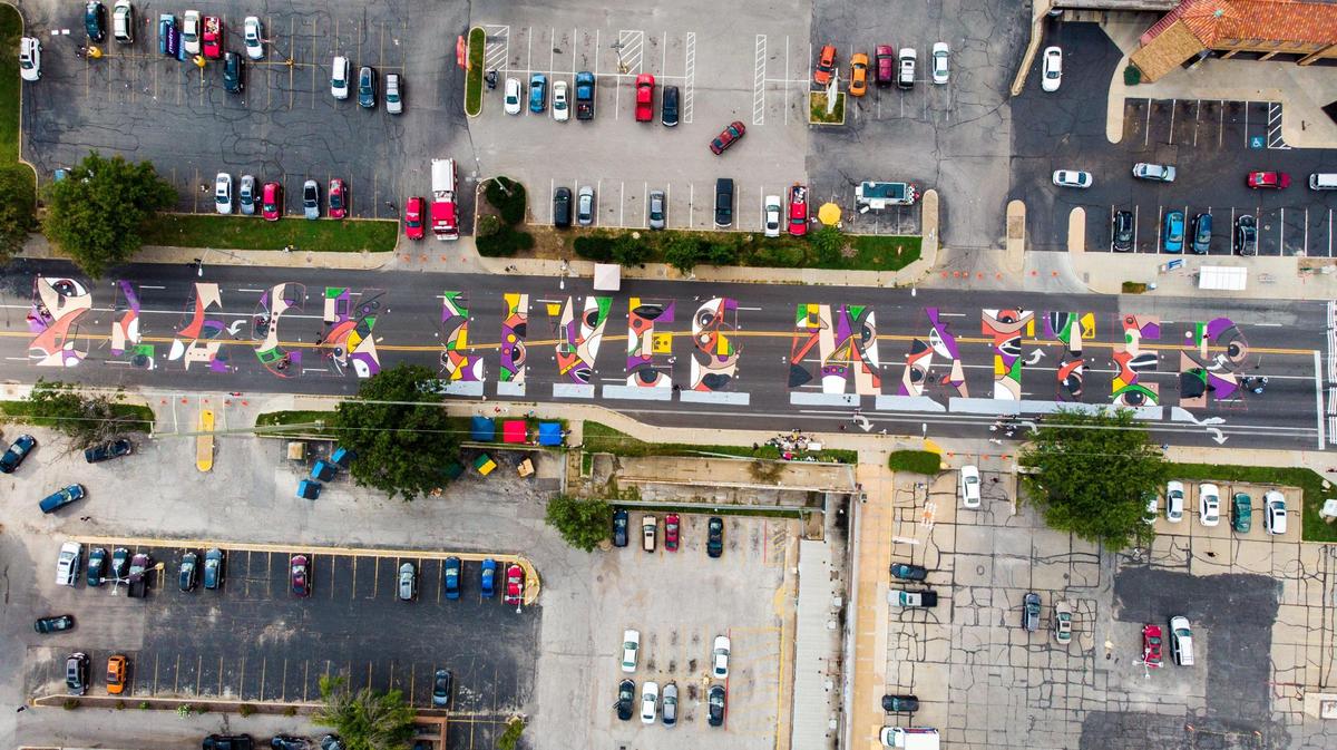 Artists and volunteers work on a giant Black Lives Matter mural at 63rd Street and Troost Avenue on Saturday, Sept. 5, 2020. Six Black Lives Matter murals were painted at the same time across Kansas City.