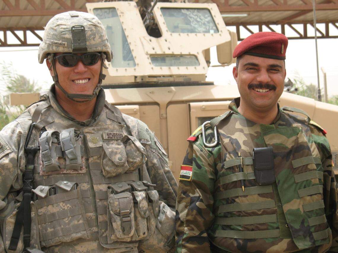 One of Patrick Schreiber's six tours of duty in a a 27-year military career included a 2007 stint as an embedded adviser in Iraq. At right stands an Iraqi soldier.