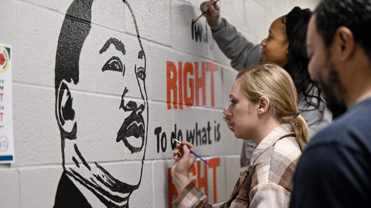 Volunteers Lauren Baratta, from left, Keyera Collins and Matt Oates, employees of Burns & McDonnell, painted a mural of Martin Luther King Jr., during MLK Day of Service at Pitcher Elementary School, 9915 East 38th Terrace, on Monday, Jan. 15, 2024, in Kansas City.