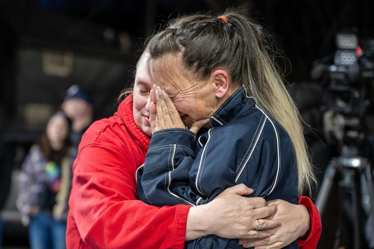 Toni Bjorklund is embraced by her sister, Tina Patrzykont, during a candlelight vigil for her daughter, Katherine Bjorklund, at Riverside Car Wash on Thursday, March 6, 2025, in Kansas City.