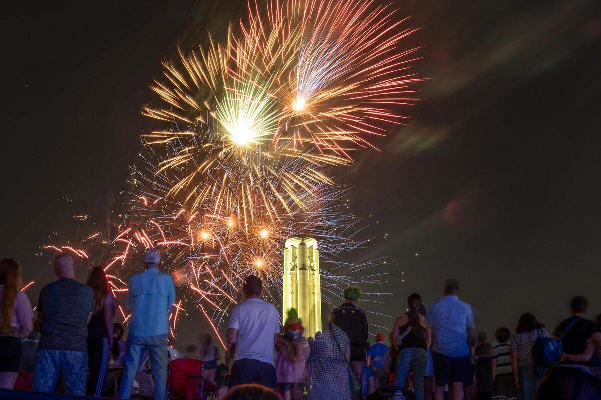 People watch and record fireworks as from the north lawn as they explode over the Liberty Memorial and the National World War I Museum at the end of the Celebration at the Station, an event featuring the Kansas City Symphony to celebrate and commemorate Memorial Day on Sunday, May 29, 2022, in Kansas City.