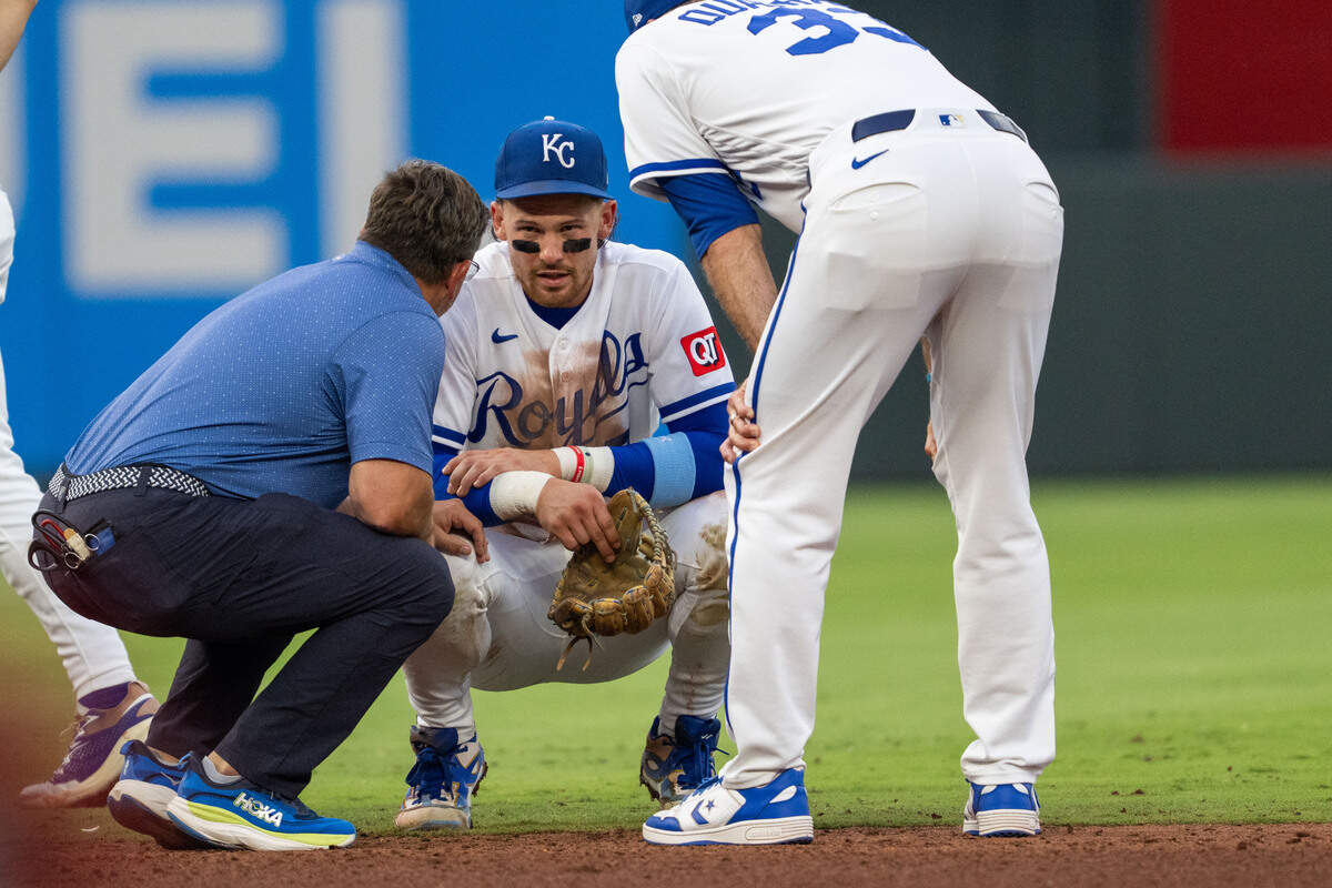 Royals shortstop Bobby Witt Jr., center, talks to manager Matt Quatraro, right, after injuring himself while fielding a ground ball during the fourth inning of a game against the St. Louis Cardinals at Kauffman Stadium in Kansas City on Thursday, June 18, 2026.