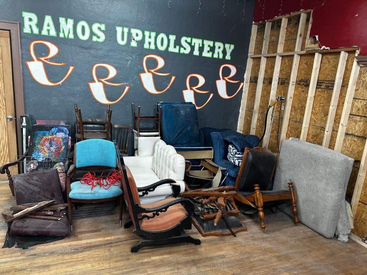 After an SUV crashed into Ramos Upholstery, a multi-generational business in the Strawberry Hill neighborhood of Kansas City, Kansas, the owners moved damaged furniture to one side of the shop. The driver suffered critical injuries when the SUV blew through a glass window into the shop shortly after 9:15 a.m. Thursday.
