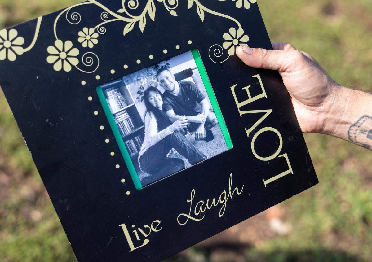 Daniel DeHaan holds up a photo of his brother, Michael DeHaan, and his mother, Tammy Housh DeHaan. Michael was killed in a shooting at a Kansas City gas station Aug. 21.