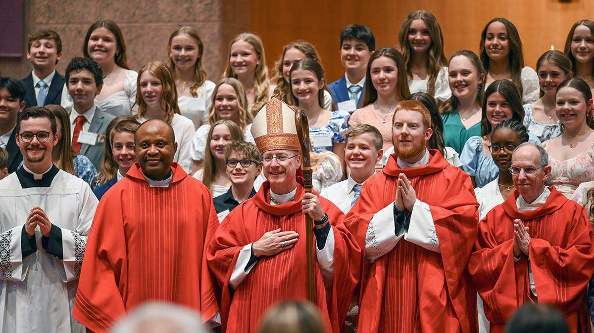 Archbishop Shawn McKnight, center