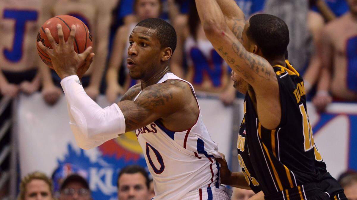 Missouri Tigers guard Marcus Denmon (12) defends against Kansas Jayhawks forward Thomas Robinson (0) in the second half at Allen Fieldhouse. Kansas won the game in overtime 87-86 on Feb. 25, 2012.