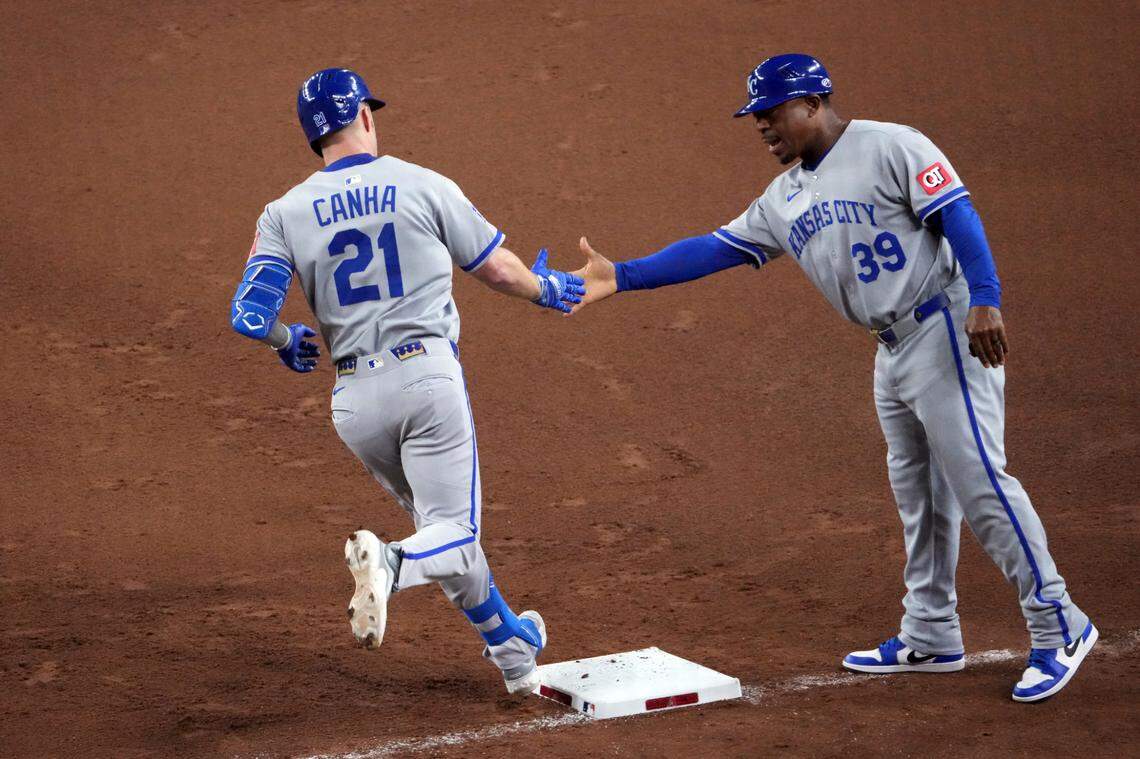 Kansas City Royals outfielder Mark Canha (21) slaps hands with Kansas City Royals first base coach Damon Hollins (39) after hitting a solo home run against the Arizona Diamondbacks during the fifth inning at Chase Field on July 4, 2025.
