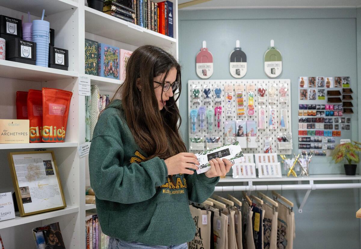 Stella Rosenthal, 13, of Overland Park, selects a young adult novel to purchase during a visit to Smitten Booktique, a mobile bookstore, on Tuesday, May 20, in Overland Park.
