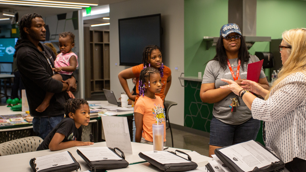 Students pick up laptops and other school supplies during orientation for Brookside Virtual Academy on Aug. 20 in Kansas City. Brian Wilson (left) said he and his wife like giving individual attention to their kids’ education at home.