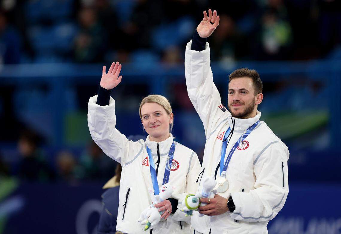 Silver medalists Korey Dropkin and Cory Thiesse of Team United States celebrate on the podium after the Mixed Doubles gold medal game at the Milano Cortina 2026 Winter Olympics.
