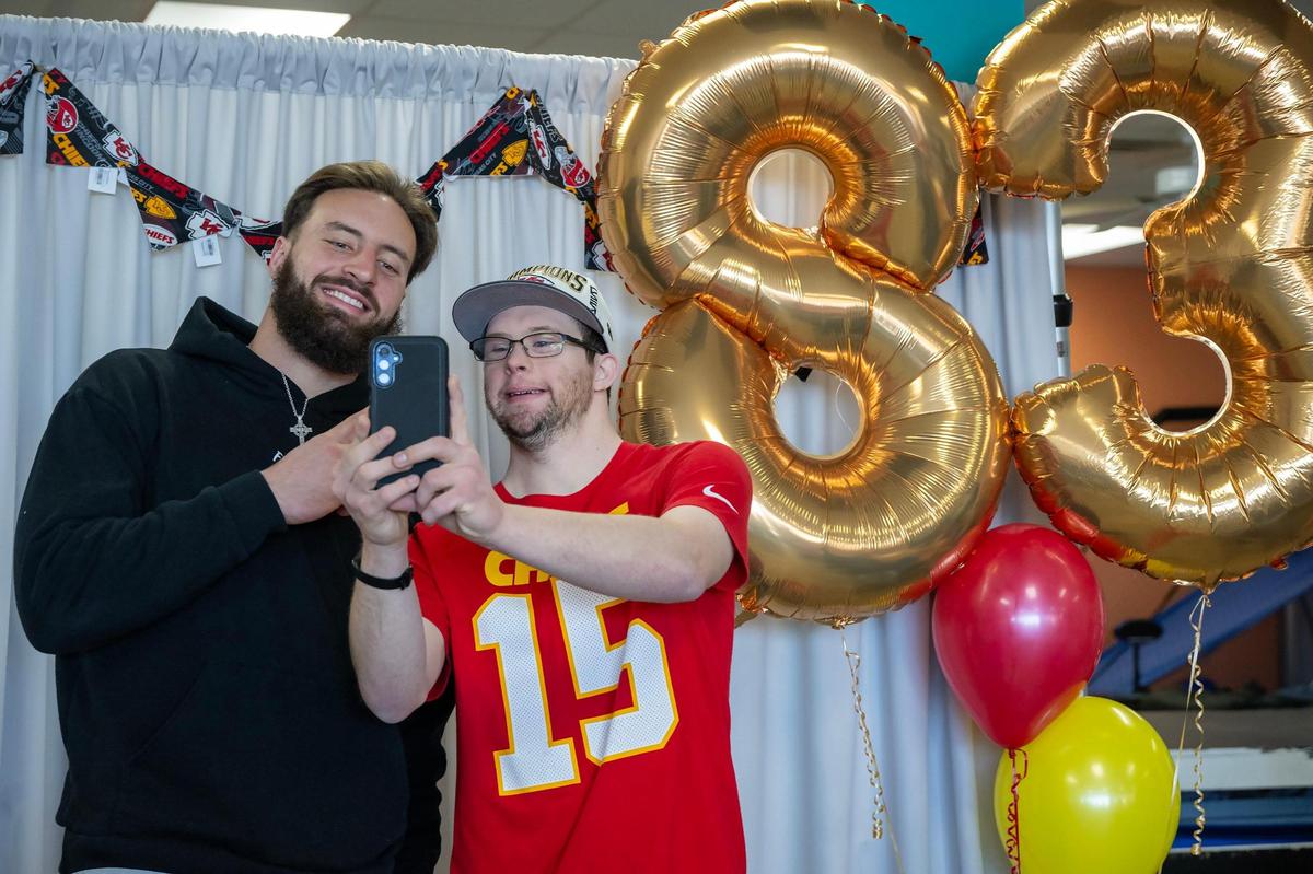 Kansas City Chiefs tight end Noah Gray took a selfie with 25-year-old Jacob Tomandl, a student at PawsAbilities during a visit on Wednesday in Olathe. The program offers jobs and workforce training for individuals with intellectual disabilities, and its students create dog treats, toys, and other pet-related products.