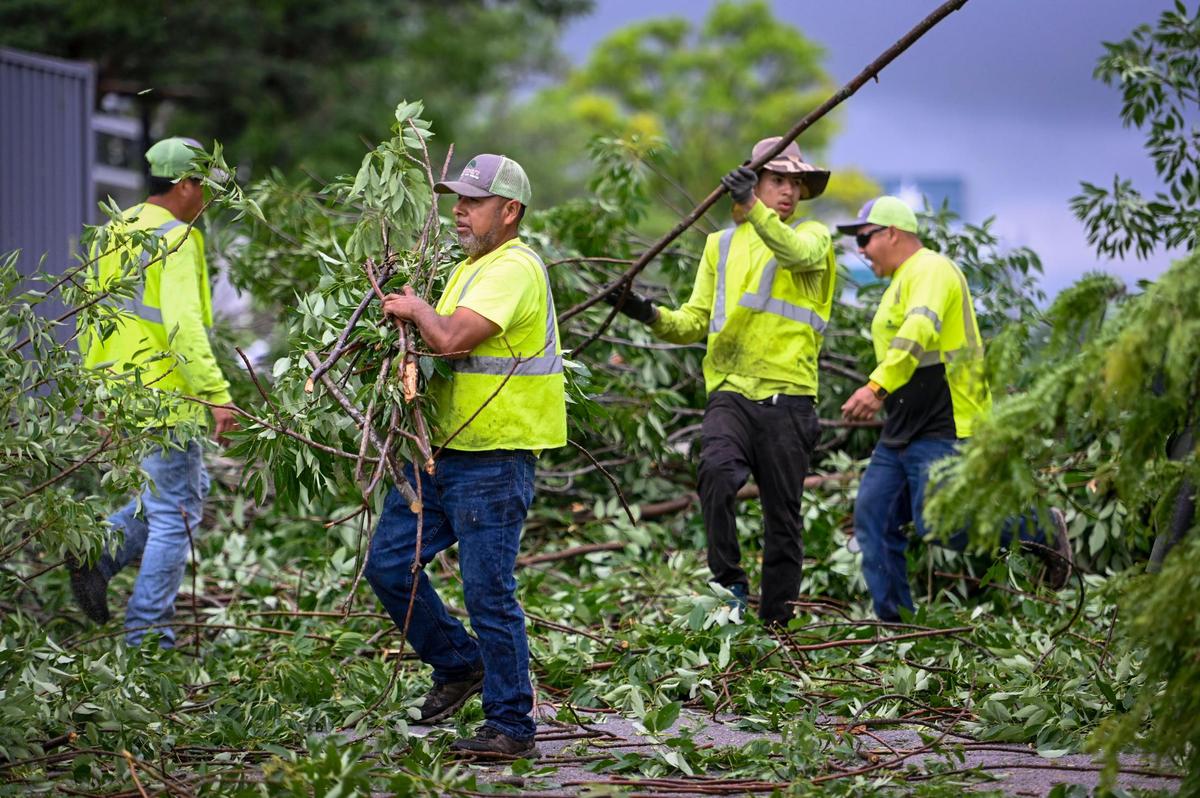 Crews cleared tree limbs and debris from the parking lot at Fiorella’s Jack Stack Barbecue at 95th Street and Metcalf Avenue in Overland Park Wednesday, June 8, 2022.