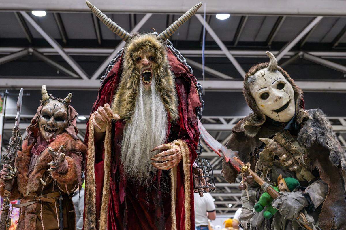Tim Gillam Jr., left, and Tim Gillam, dressed as Krampus, along with Riddick Ackerman, pose for a portrait during Planet Comicon at the Kansas City Convention Center on Friday, March 21, 2025.