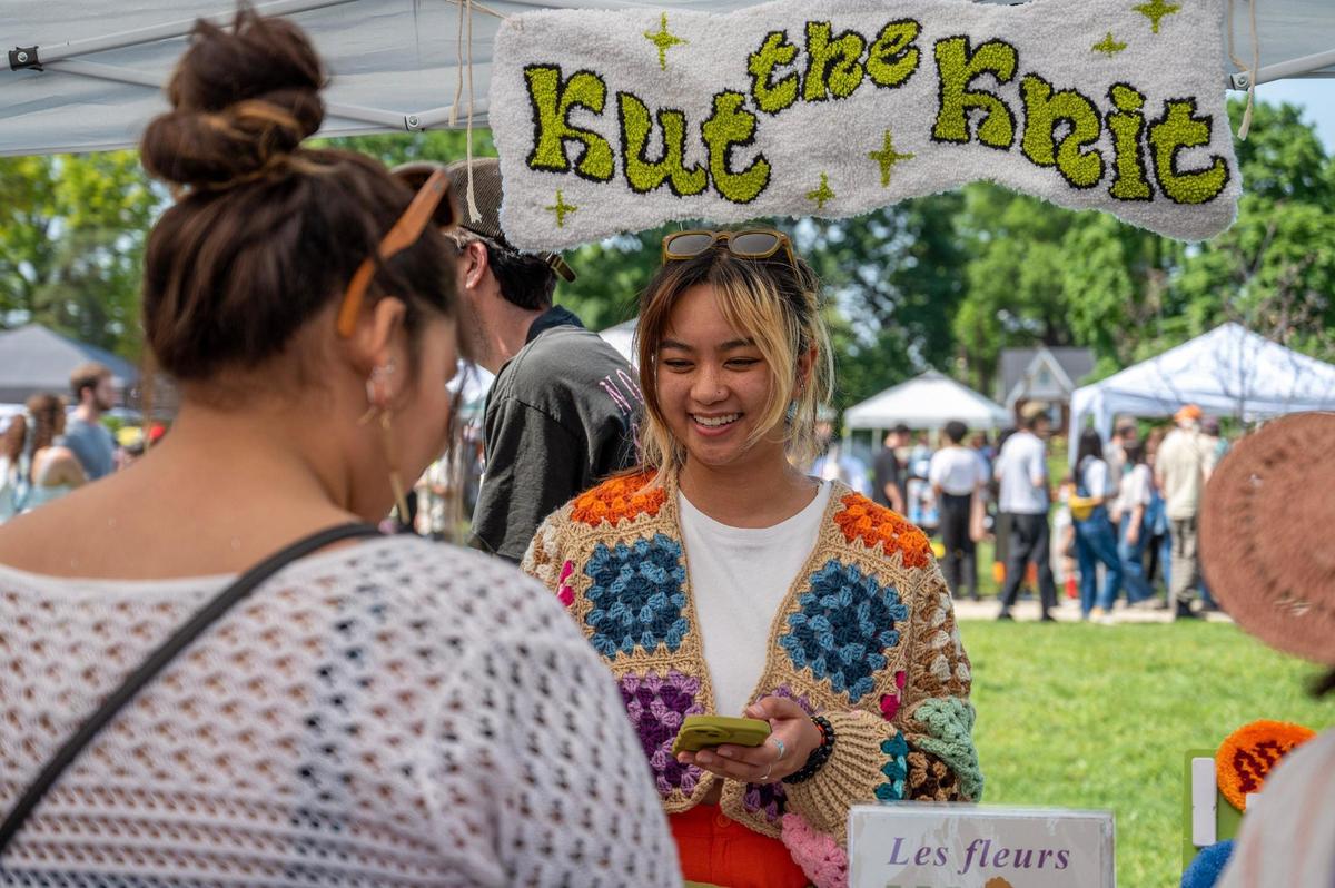 Kat Cacho helps a customer purchase an item at the Kut the Knit booth during the AAPIconic Festival on Saturday, May 20, 2023, in Kansas City.