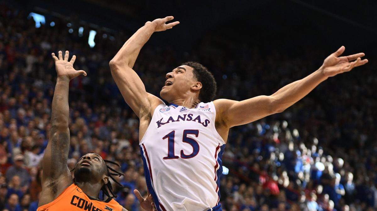 KU’s Kevin McCullar lets go of a runner over OSU’s Chris Harris during the second half of a Big 12 Conference game at Allen Fieldhouse on New Year’s Eve. KU beat Oklahoma State 69-67.