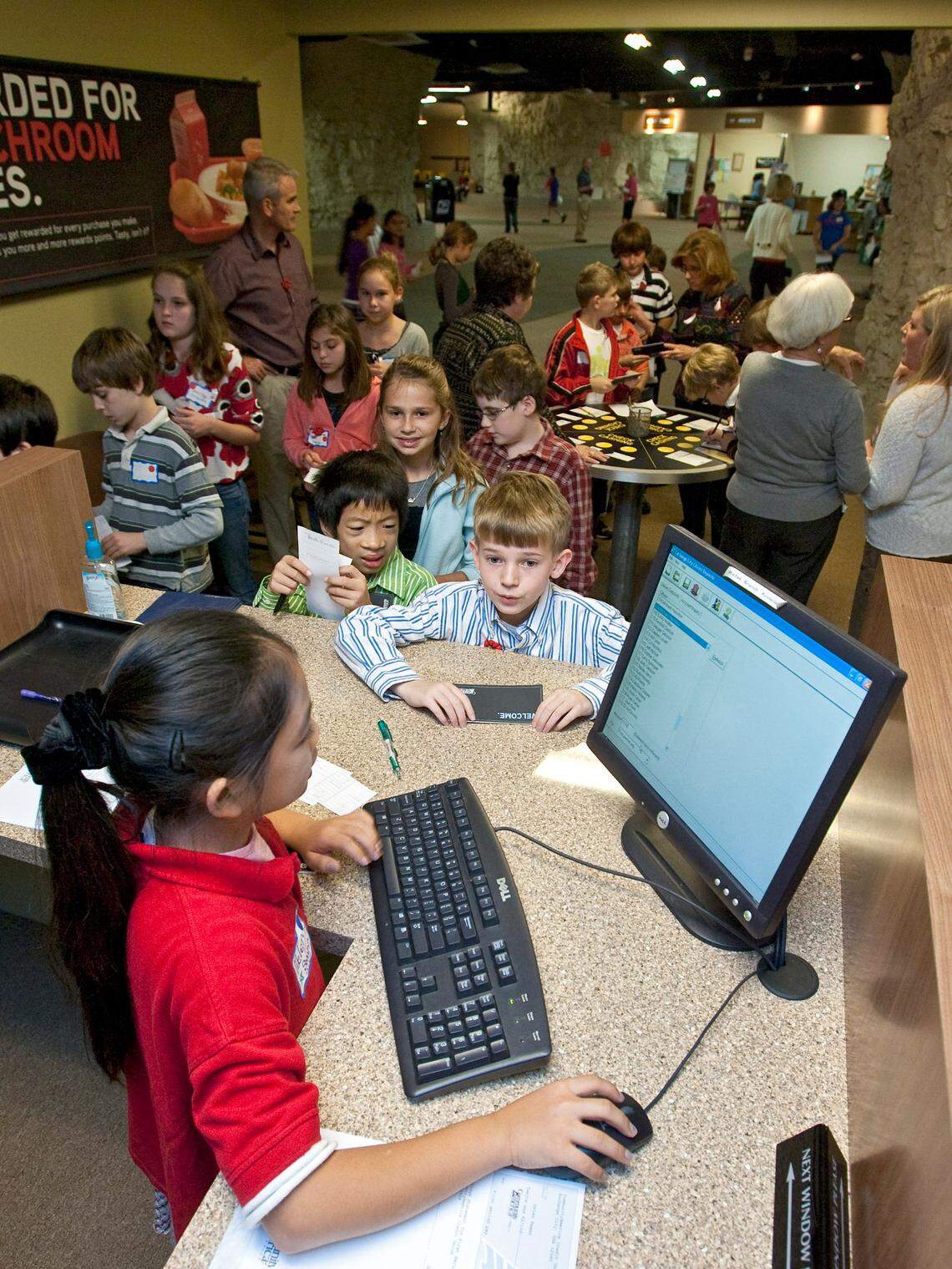 A bank teller helped a long line of students waiting to cash their paychecks at Exchange City in 2009.