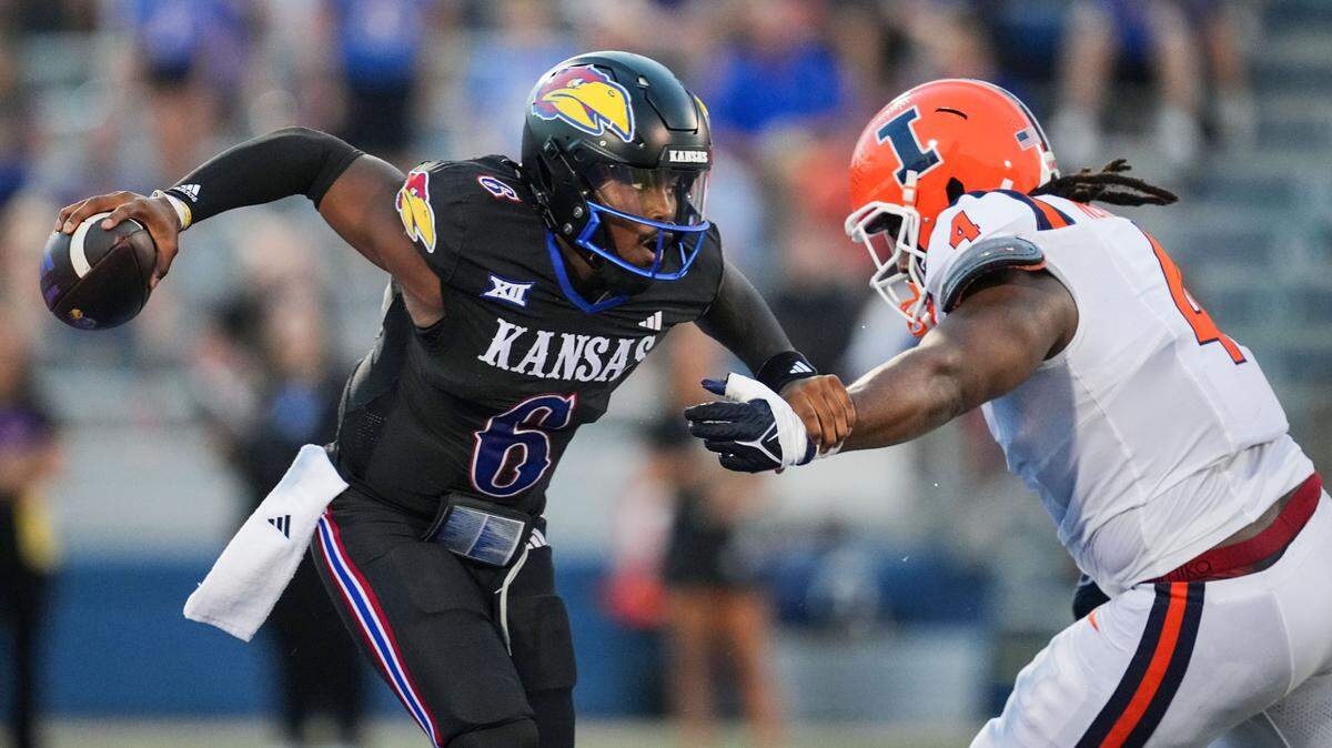 Kansas Jayhawks quarterback Jalon Daniels (6) scrambles from Illinois Fighting Illini defensive lineman Jer’Zhan Newton (4) during the first half at David Booth Kansas Memorial Stadium on Sept. 8, 2023.