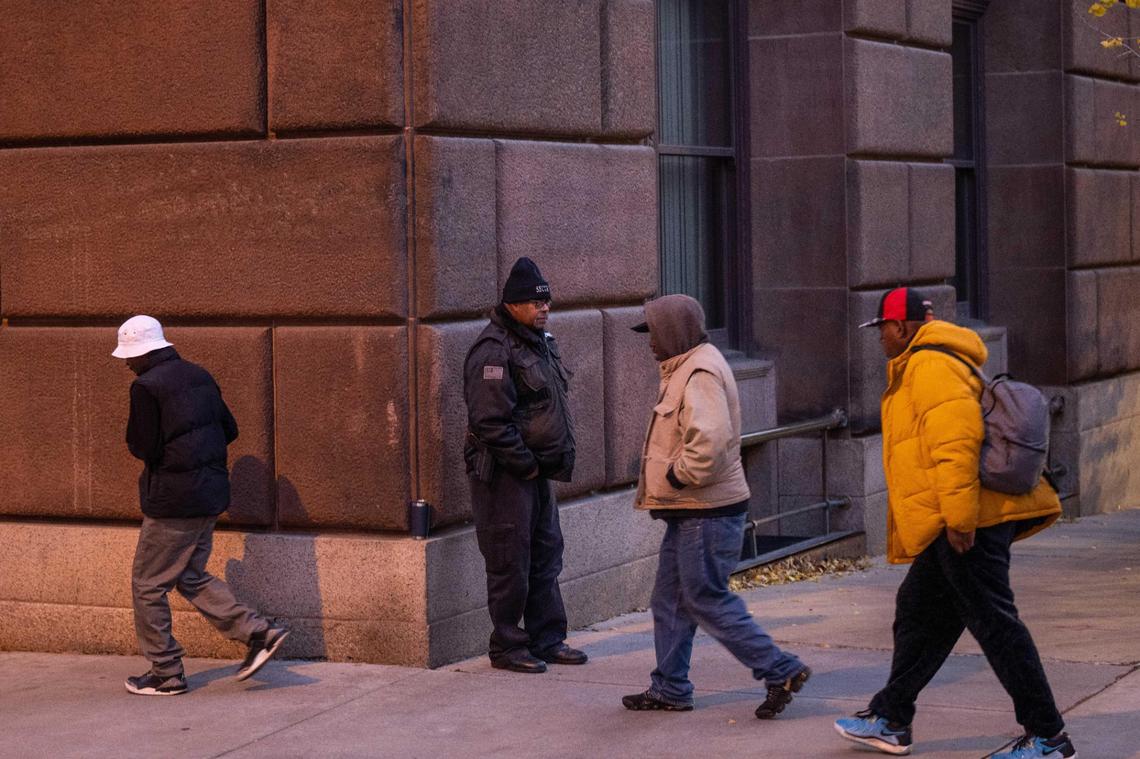 Security keeps an eye on homeless people Monday morning near the headquarters of the Morning Glory Ministries, a food service in downtown Kansas City run by the Catholic diocese.