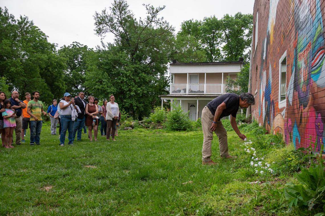 Pedro Calderon sets down a candle as people gather in front of the mural at the Latinx Education Collaborative for the “Vigilia para nuestros niños” (Vigil for Our Children) to honor children lost to school violence on Tuesday, May 31, 2022, in Kansas City.