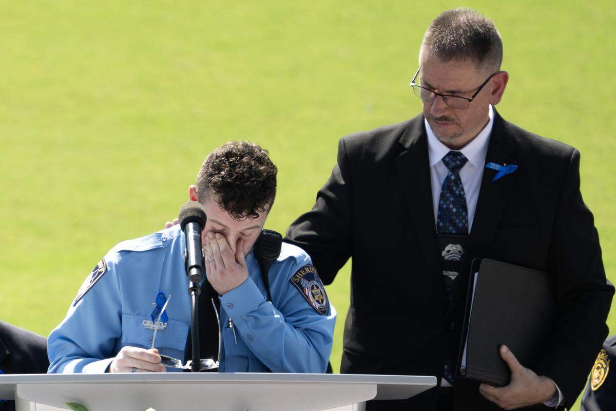 Deputy Blake Fisher wipes away tears while speaking during Officer Hunter Simoncic's memorial service at Children's Mercy Park on Wednesday, Sept. 3, 2025, in Kansas City, Kansas. Simoncic was killed Aug. 26 after being struck by a fleeing driver while deploying stop sticks.
