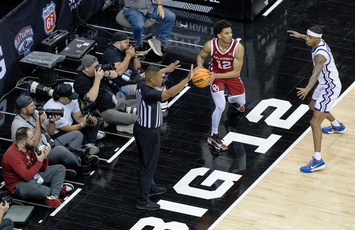 To get the best action shots, credentialed photographers take photos of the game from their assigned positions along the baselines on either ends of the court during the Big 12 tournament at the T-Mobile Center. Some of the photographers have remote cameras set up on positions along the floor or attached to the goal standards which they trigger with remote controls while also using their handheld cameras. Photographers captured the action of Oklahoma playing TCU on Wednesday.