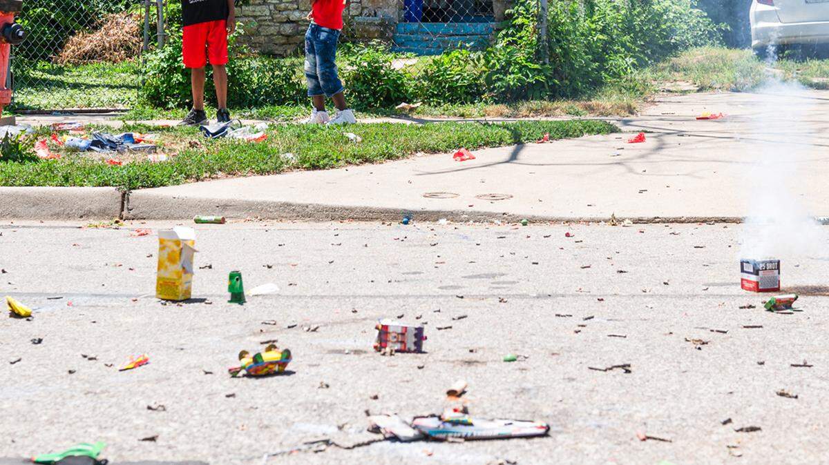 Cherish Swinton, left, Tashawn Swinton, and Knowledge Thompson light off fireworks in the street on Tuesday, July 4, 2023, in Kansas City. Firework debris littered the streets from the Fourth of July celebrations across the city. 