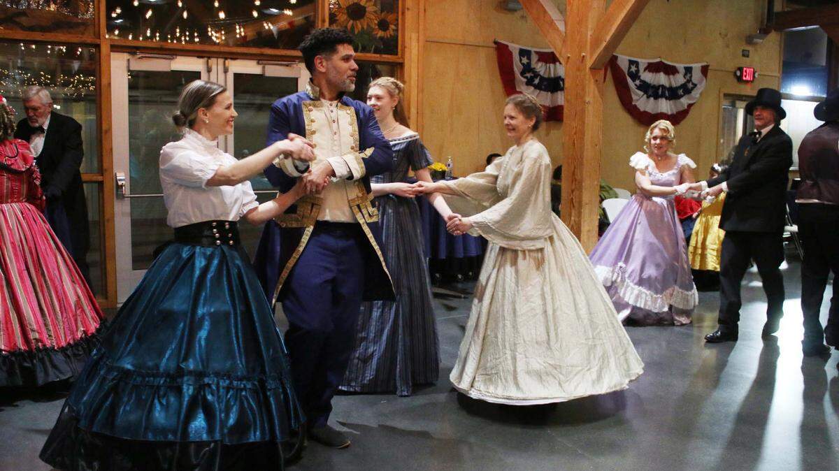Olathe residents Allison Gregory and Aaron Gregory take part in one of the group dances at Mahaffie’s 1860s dance party Jan. 27.