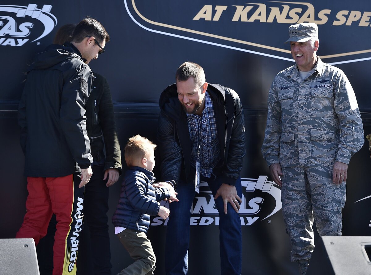 Royals outfielder Alex Gordon (second right) high-fives Owen Larson, son of NASCAR driver Kyle Larson, during driver introductions before the Monster Energy NASCAR Cup Series Hollywood Casino 400 at Kansas Speedway on Sunday.