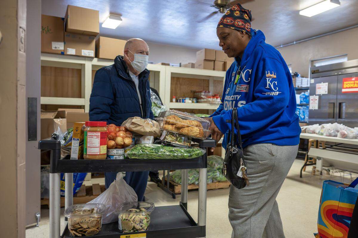 Cynthia Ransburg wheels a cart filled with food at the Redemptorist Center food pantry on Monday, Nov. 3, 2025, in Kansas City. Food pantries across the region are struggling to meet demand as many families face reduced or frozen SNAP benefits.