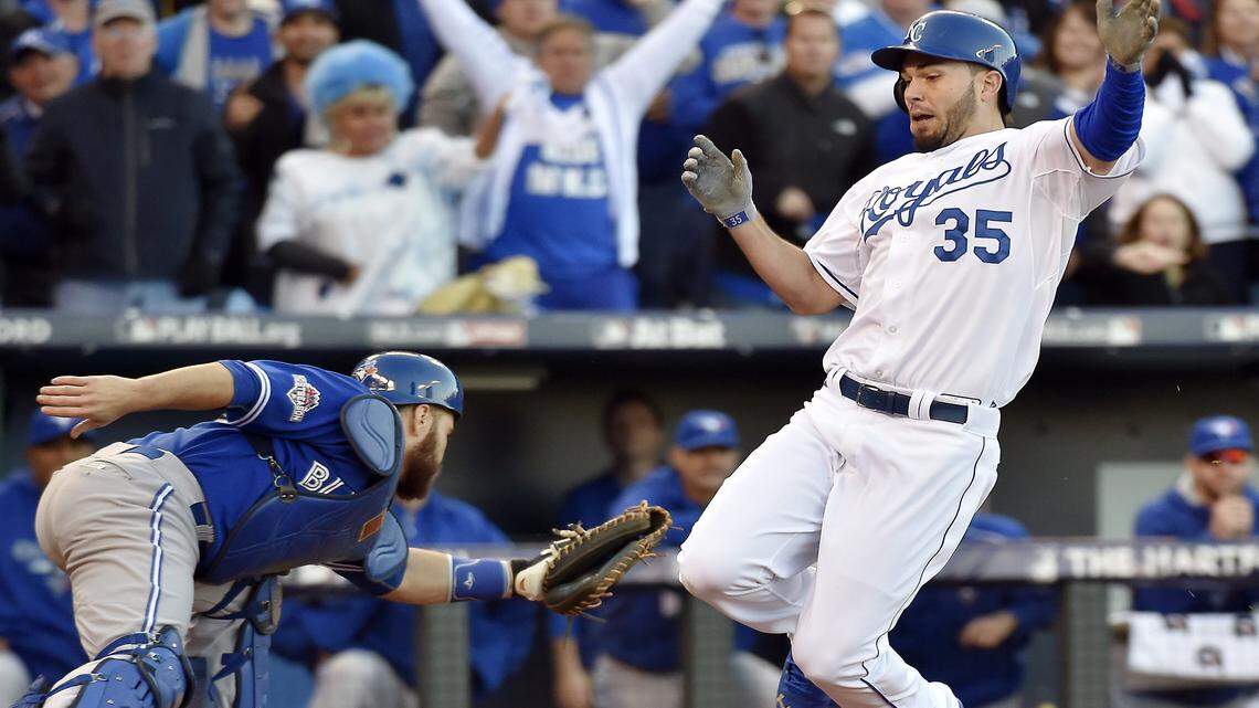 Royals first baseman Eric Hosmer slides in past the tag of Blue Jays catcher Russell Martin to score on a single by third baseman Mike Moustakas to tie Toronto 3-3 during Saturday's ALCS baseball game at Kauffman Stadium.
