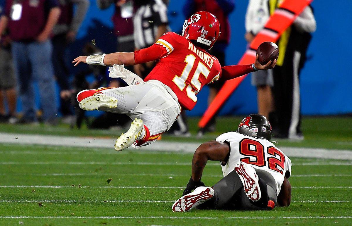 Kansas City Chiefs quarterback Patrick Mahomes is tripped up by Tampa Bay Buccaneers defensive end William Gholston and flies through the air as he gets off a pass to the end zone in the fourth quarter Sunday, February 7, 2021, at Super Bowl LV at Raymond James Stadium in Tampa, Florida. The pass was incomplete.