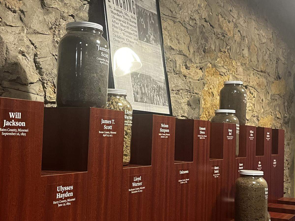 Jars filled with the soil from the sites where Black people were lynched in Missouri line the walls of an exhibit at the Black Archives of Mid-America in Kansas City.