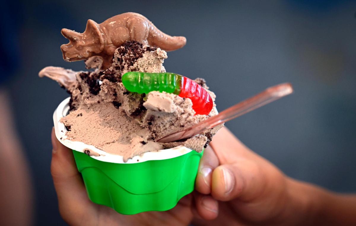 A customer shows off the Dirt Worms N’ Dino gelato at The Flying Cow Gelato Shop.